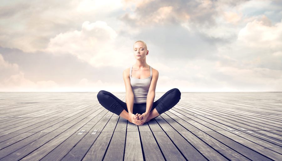 Woman Meditating on Dreamy Parquet Floor With Clouds